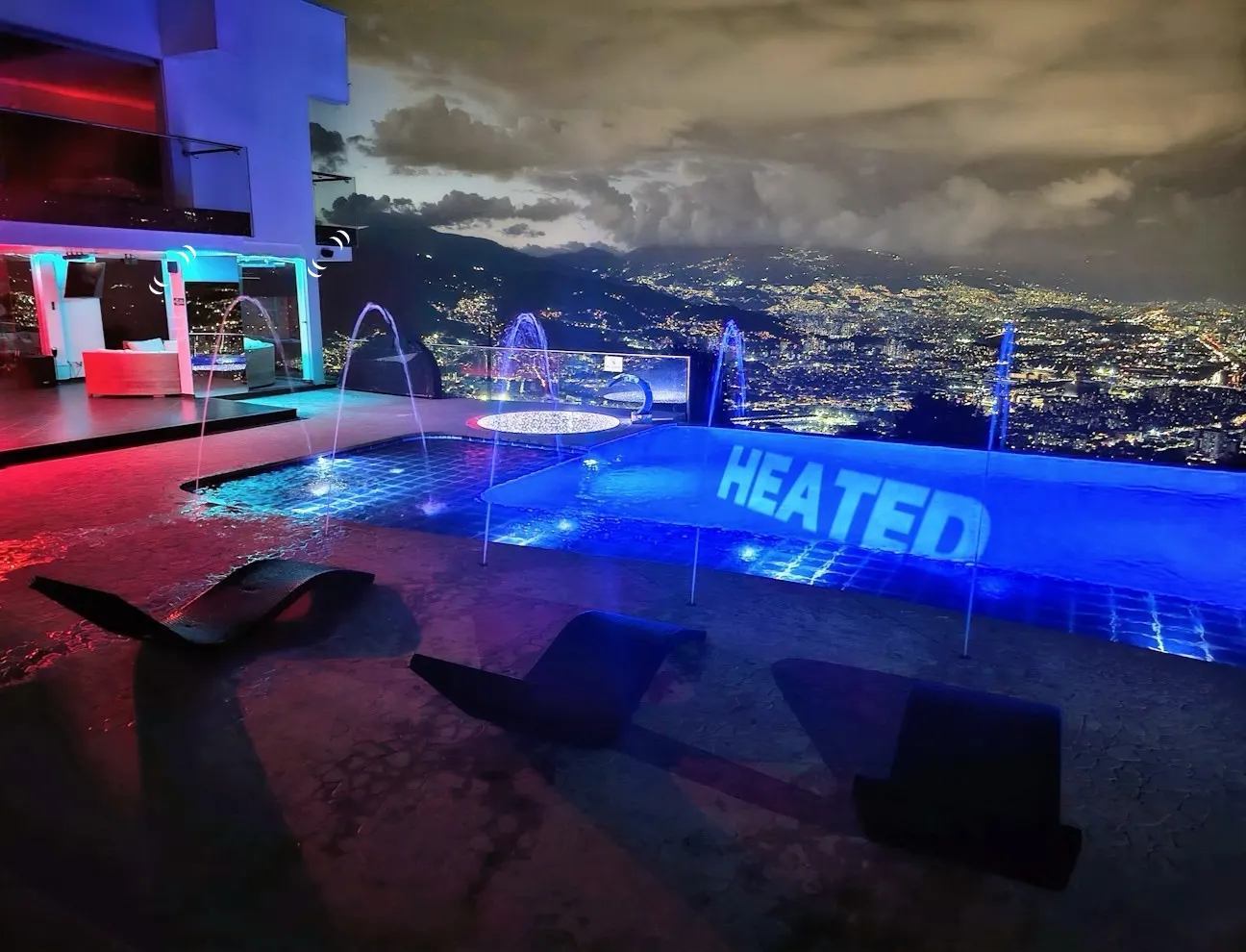Heated pool and jacuzzi overlooking the illuminated valley at night